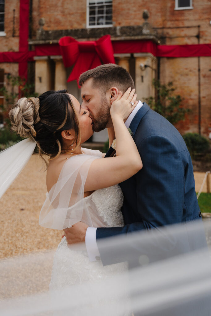 Elcott Park wedding photography with couple standing outside manor