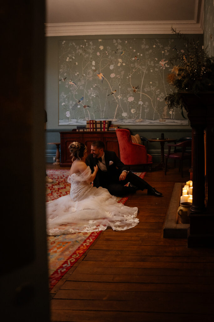 Couple drinking cocktails by the fire at Elcott Park for wedding