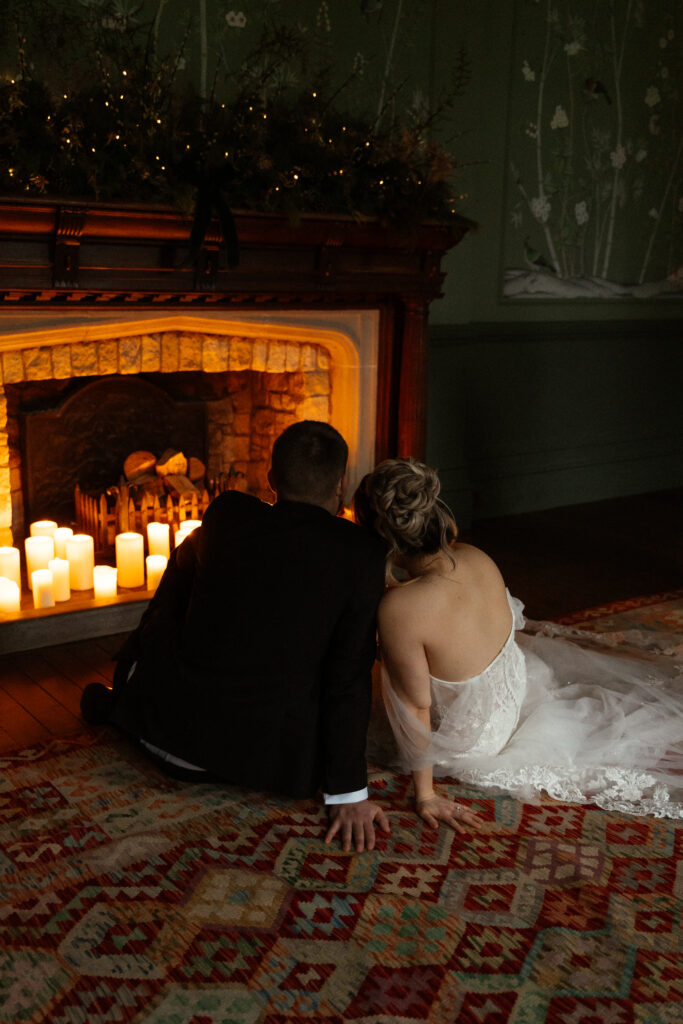 Couple drinking cocktails by the fire at Elcott Park for wedding