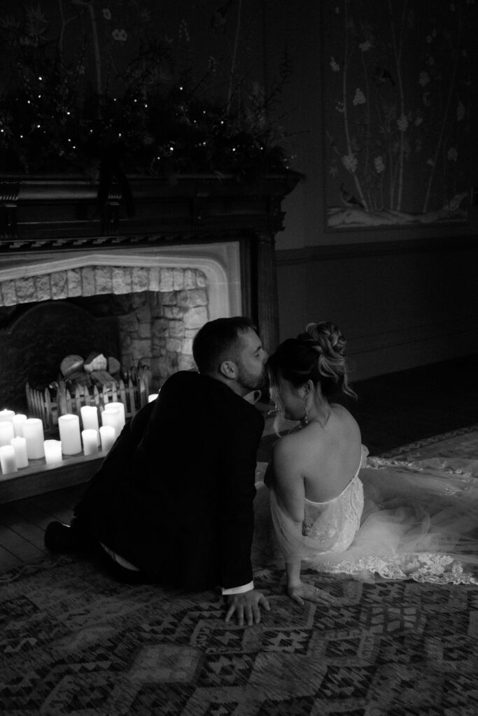 Couple drinking cocktails by the fire at Elcott Park for wedding