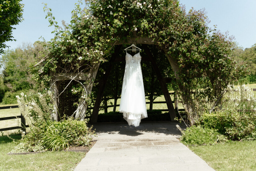 dress hanging at the arbour at Hyde House by Cotswolds wedding photographer