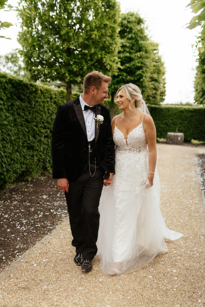 bride and groom walking in grounds of hyde house by cotswolds wedding photographer