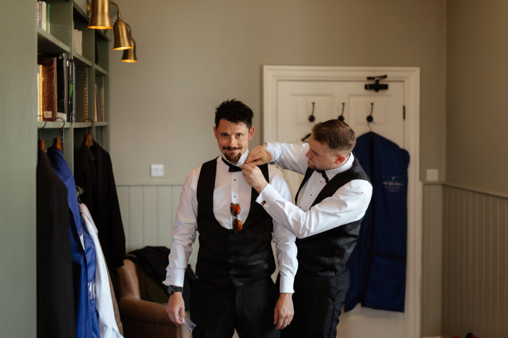 Groom prep in the library at Hyde House by Cotswolds wedding photographer
