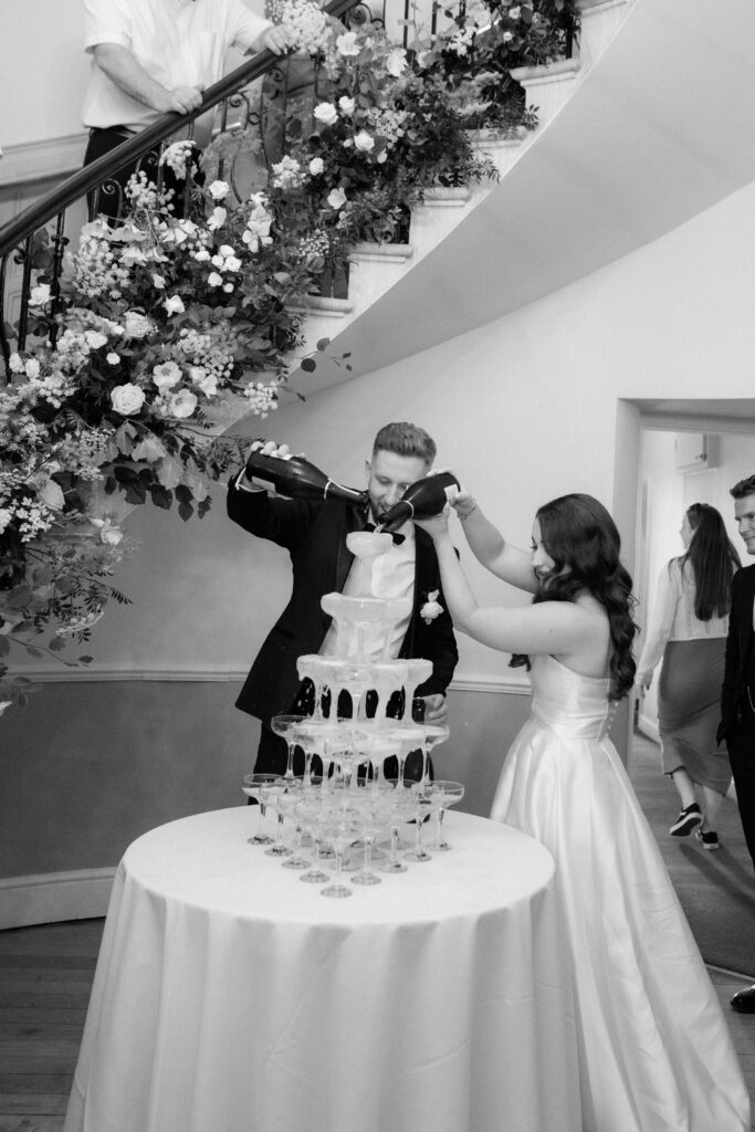 Champagne tower with bride and groom at Eastington Park by Cotswolds wedding photographer