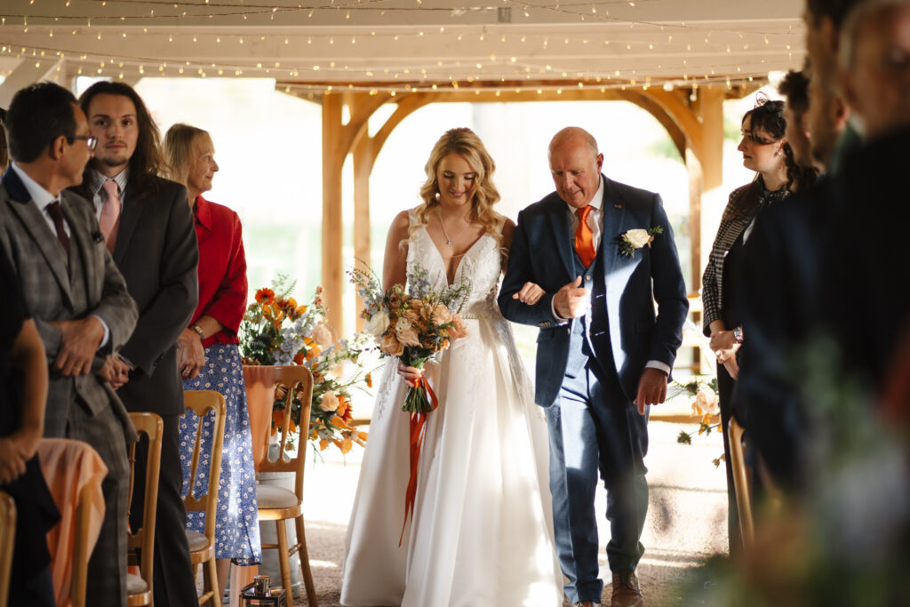 outdoor ceremony under a pergola at brinsop court for autumn wedding by hereford wedding photographer