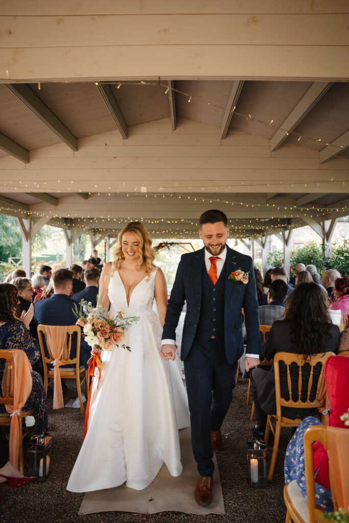 outdoor ceremony under a pergola at brinsop court for autumn wedding by hereford wedding photographer